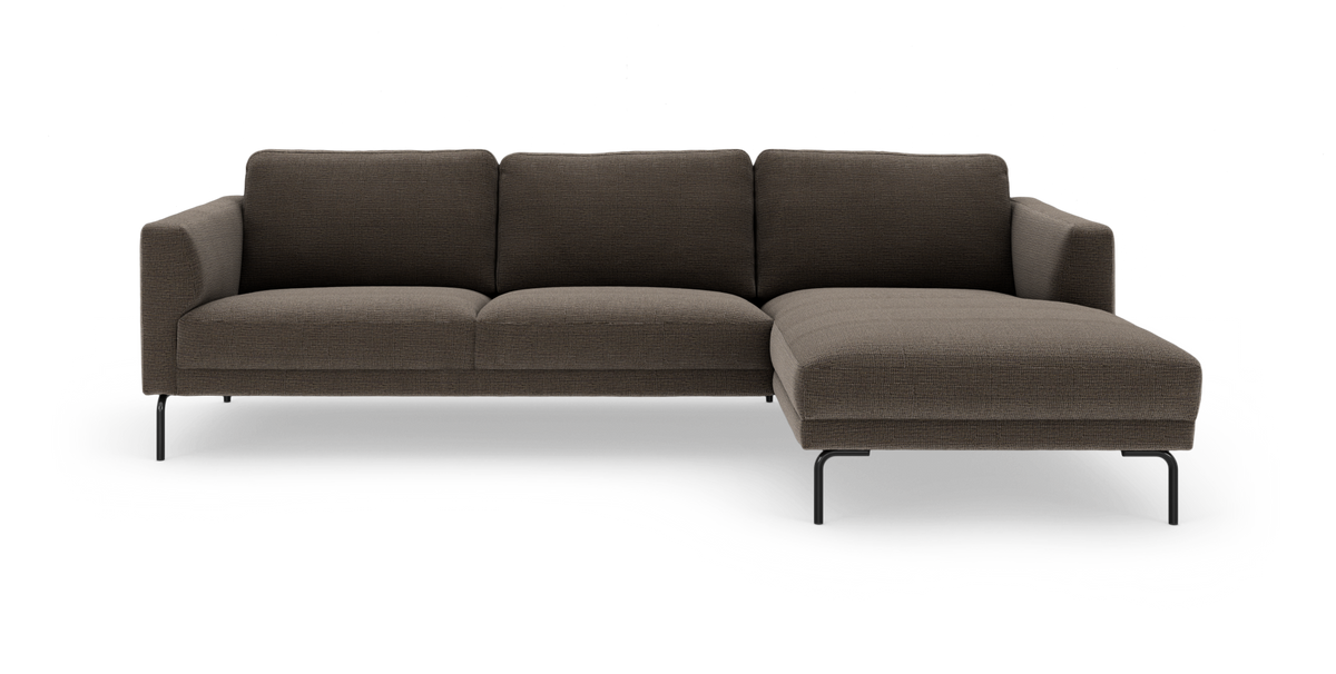 Højrevendt hjørnesofa med chaiselong i mørkebrun stof og slanke sorte ben, fritlagt på hvid baggrund.