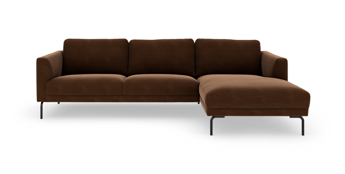 Brun hjørnesofa med chaiselong til højre på slanke sorte ben, fritlagt på hvid baggrund.