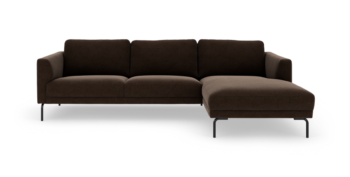 Mørkebrun modulsofa med højrevendt chaiselong på slanke sorte metalben, frilagt på hvid baggrund.