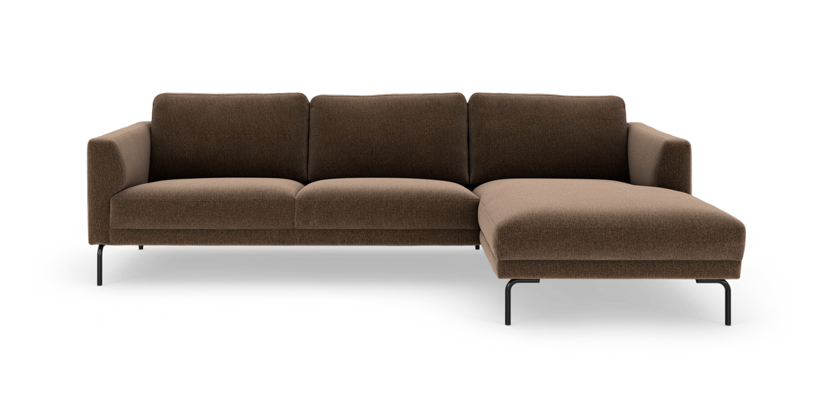 Brun modulsofa med chaiselong til højre og sorte metalben, frilagt i studiemiljø.