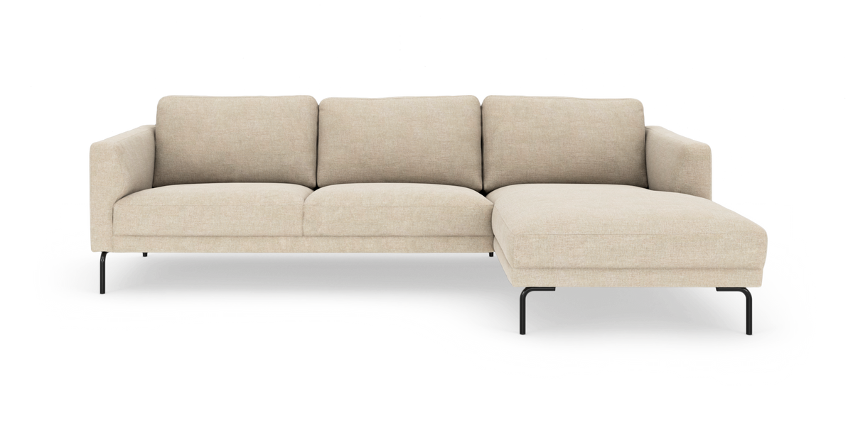 Beige hjørnesofa med højre chaiselong på slanke sorte metalben, moderne og minimalistisk, set lige forfra mod hvid studiebaggrund.