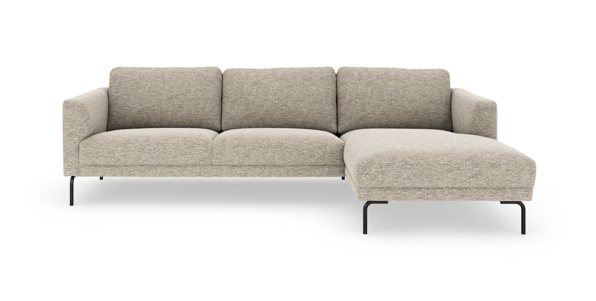 Beige L‑formet modulsofa med chaiselong til højre og sorte metalben, frilagt på hvid baggrund.