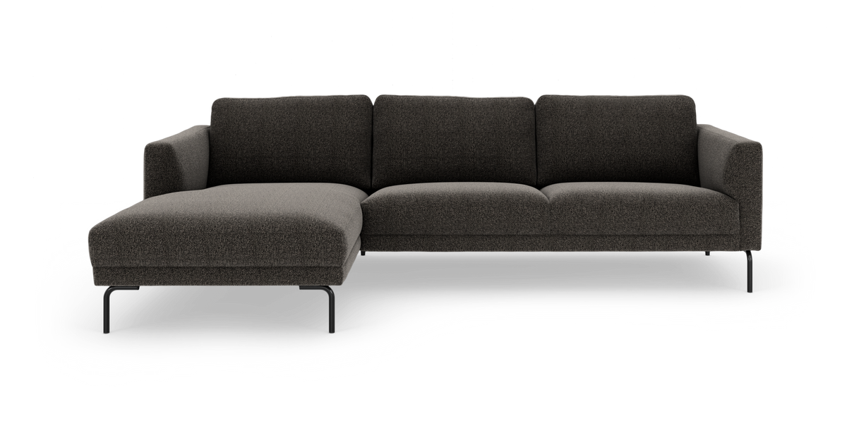Mørkegrå modulsofa med venstrevendt chaiselong på slanke sorte ben, frilagt på hvid baggrund.