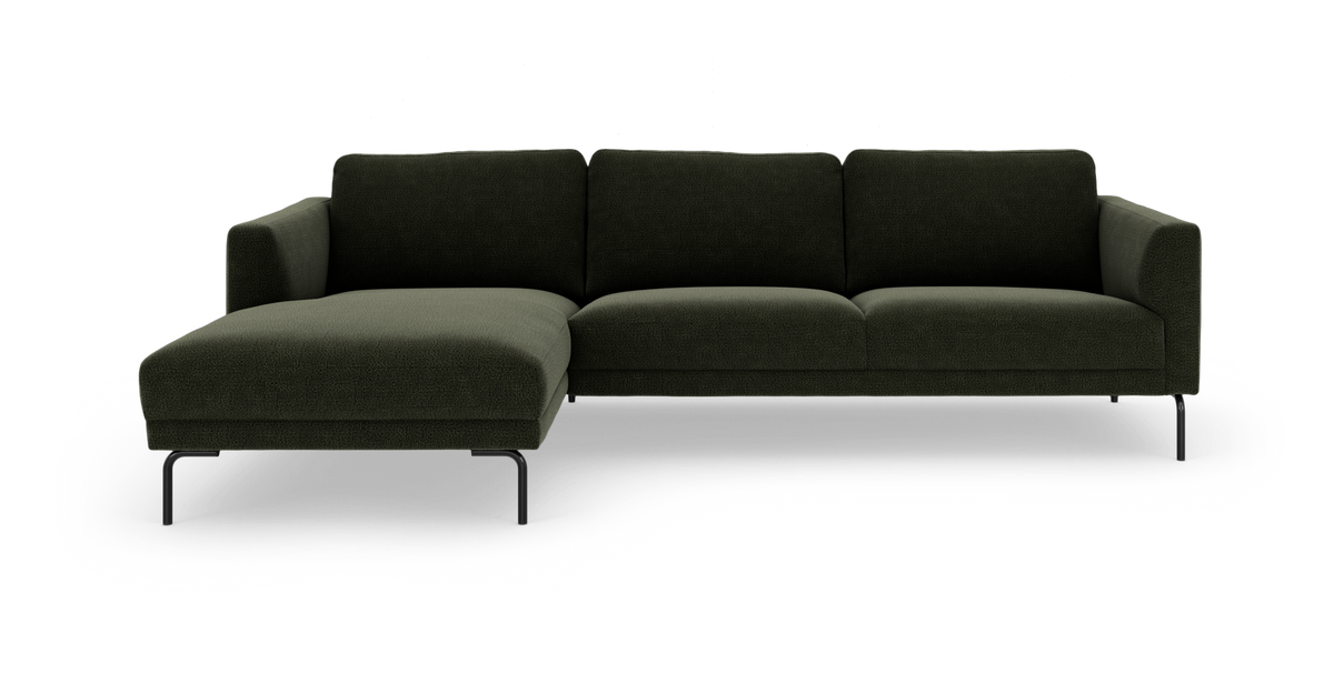 Mørkegrøn modulsofa med chaiselong til venstre og slanke sorte ben, frilagt på hvid baggrund.