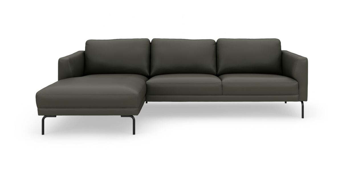 Mørkegrøn modulsofa med venstrevendt chaiselong på slanke sorte ben, frilagt på hvid baggrund.