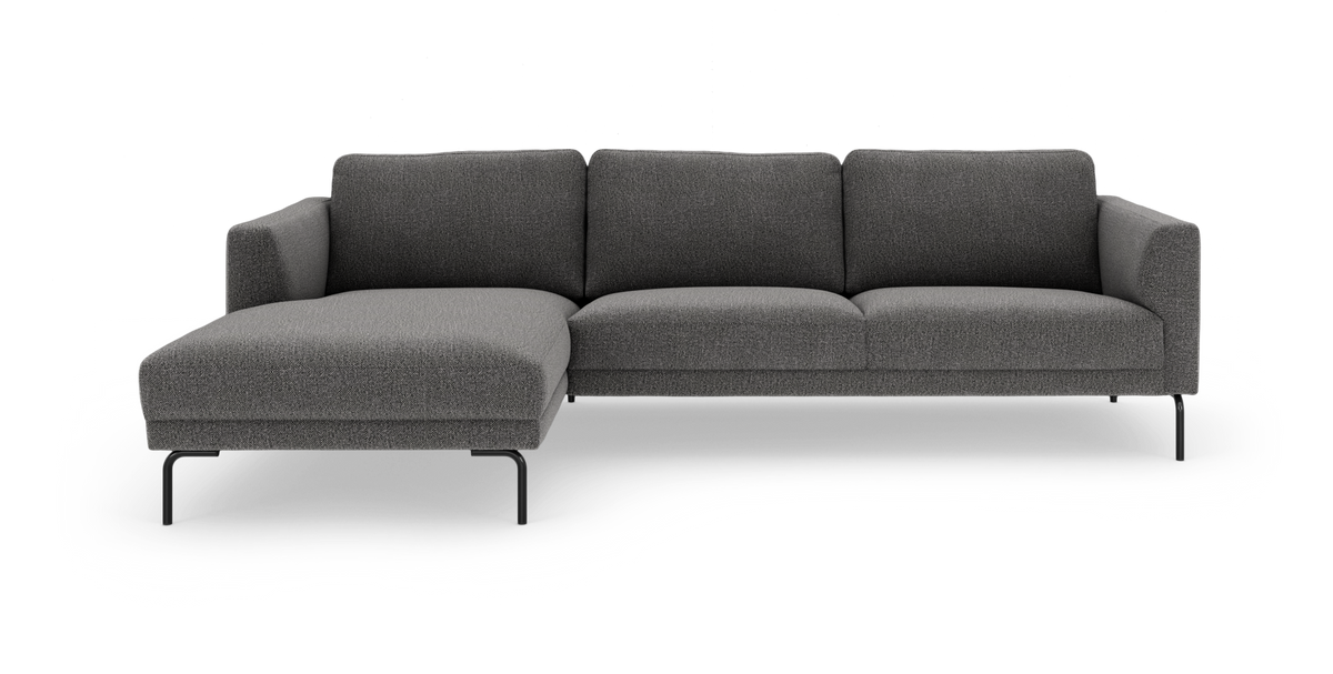 Mørkegrå modulsofa med venstrevendt chaiselong og slanke sorte ben, frilagt på hvid baggrund.