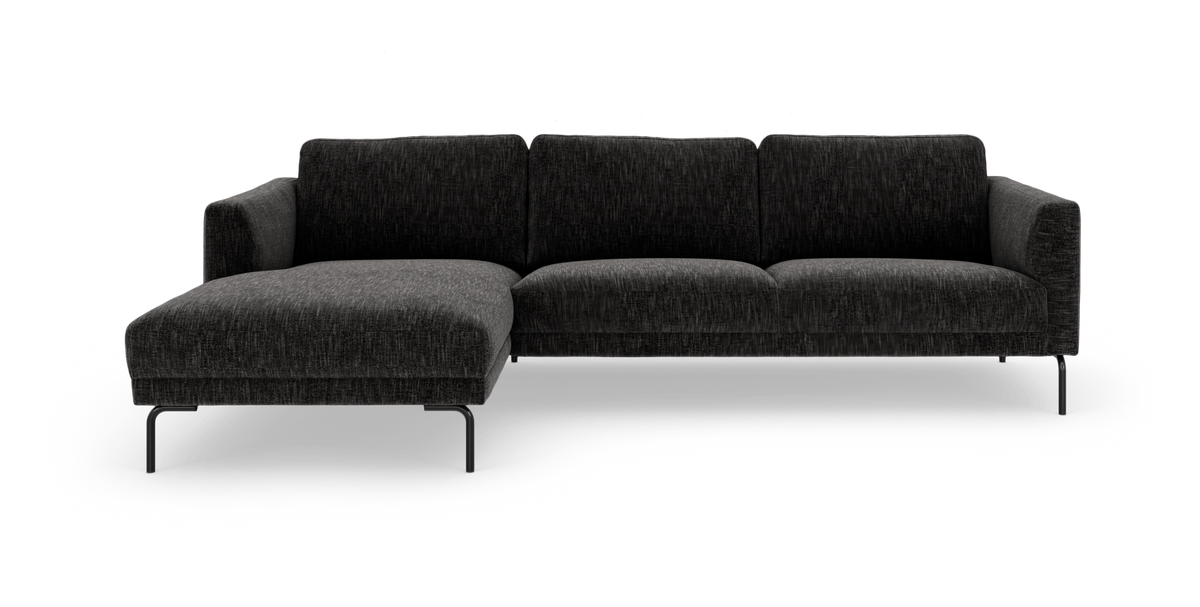 Mørkegrå hjørnesofa med venstrevendt chaiselong og slanke sorte ben, frilagt på hvid baggrund.