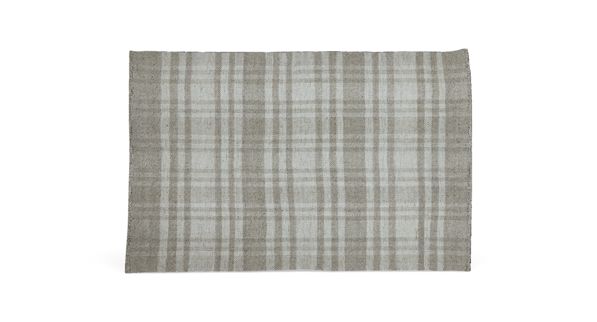 Lyst og moderne stue med beige sofa, grå puf, glas-sofabord med sorte ben, lys og stearinlys, neutral tæppe og hylder med planter og dekoration i dagslys fra store vinduer med lette gardiner.