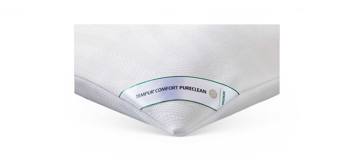 Hvid TEMPUR Comfort PureClean-pude med mærkning MEDIUM i close-up mod sort baggrund.