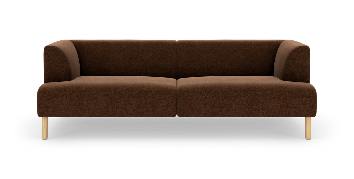 Brun modulsofa i tekstil med afrundede armlæn og lyse træben, fotograferet forfra på hvid baggrund.
