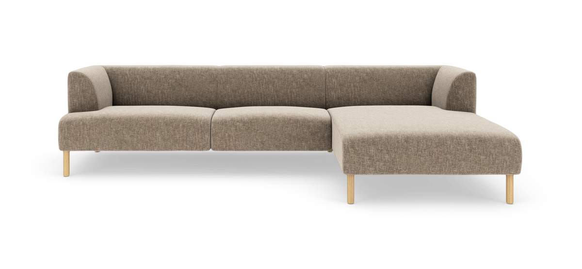 Modulsofa i beige stof med højrevendt chaiselong og lyse træben, frilagt på hvid baggrund.
