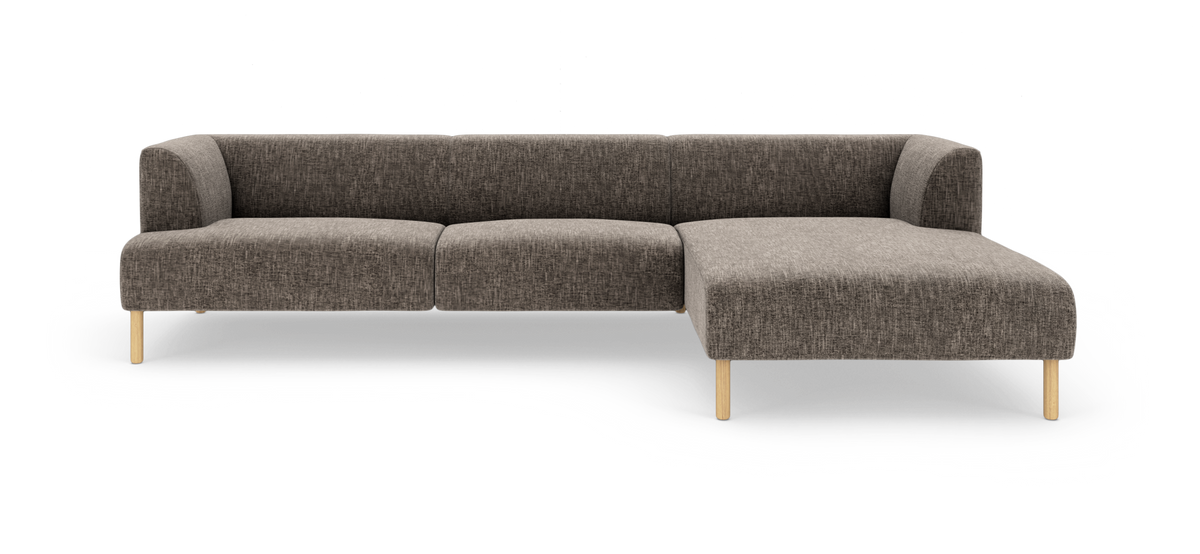 Brungrå modulsofa i L‑form med højre chaiselong, stofbetræk og lyse træben, frilagt på hvid baggrund.