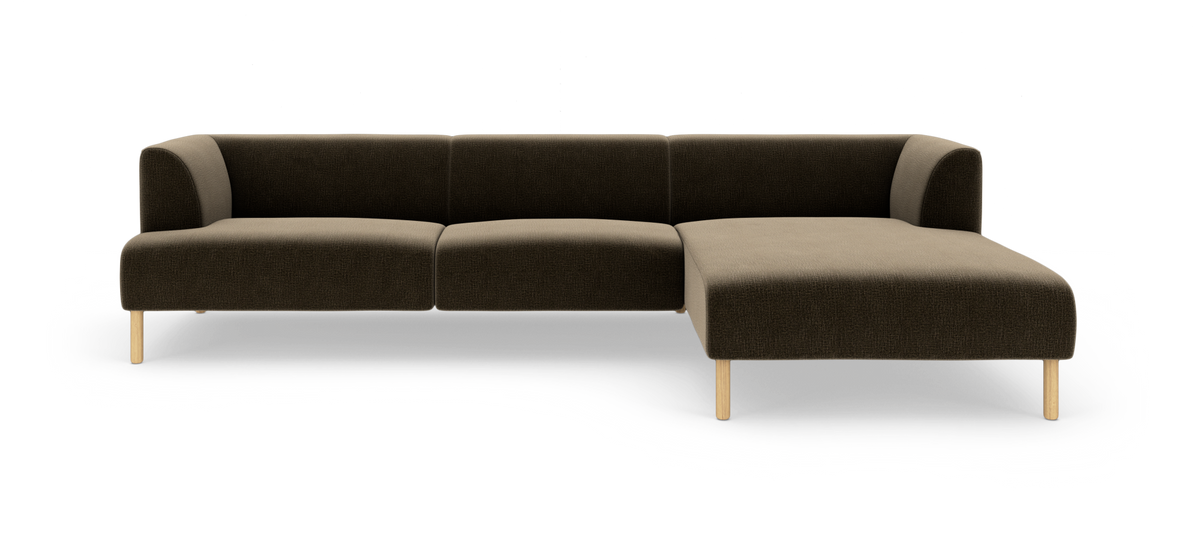 Modulær hjørnesofa med chaiselong til højre i mørkebrun tekstil og lyse træben, frilagt på hvid baggrund.