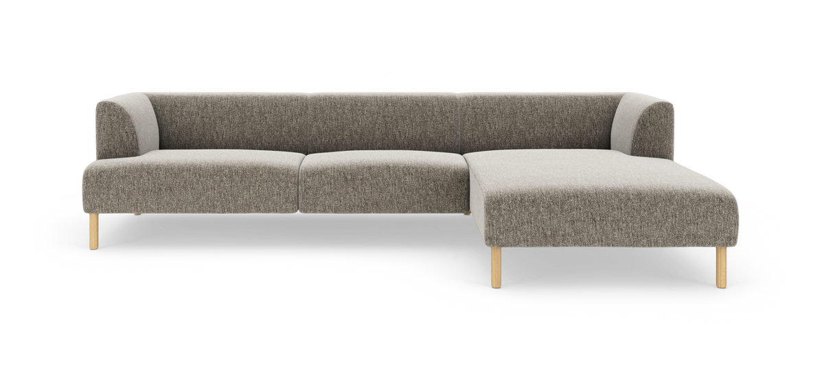 Modulsofa i stof med chaiselong til højre, gråbeige betræk og lyse træben.
