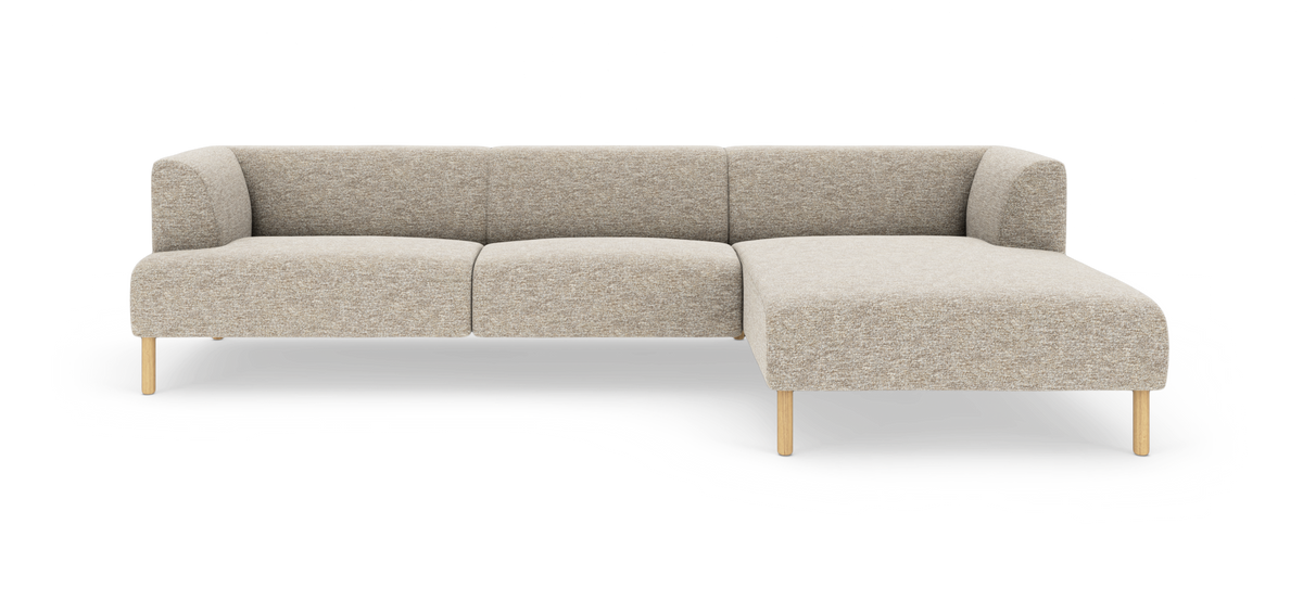 Beige modulsofa med chaiselong til højre, træben og afrundede armlæn, fritlagt på hvid baggrund.
