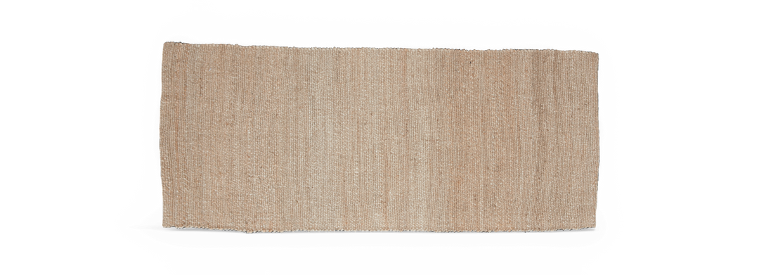 Rektangulært beige tæppe i naturmateriale, fritlagt på sort baggrund.