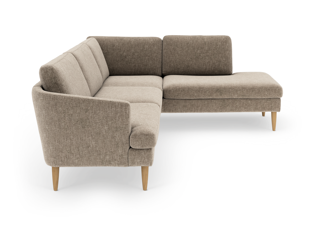 Beige L‑sofa med chaiselong til højre og lyse træben.