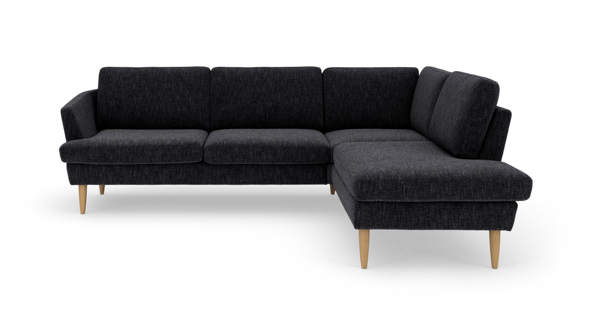 Mørkegrå L‑sofa med chaiselong til højre og træben.