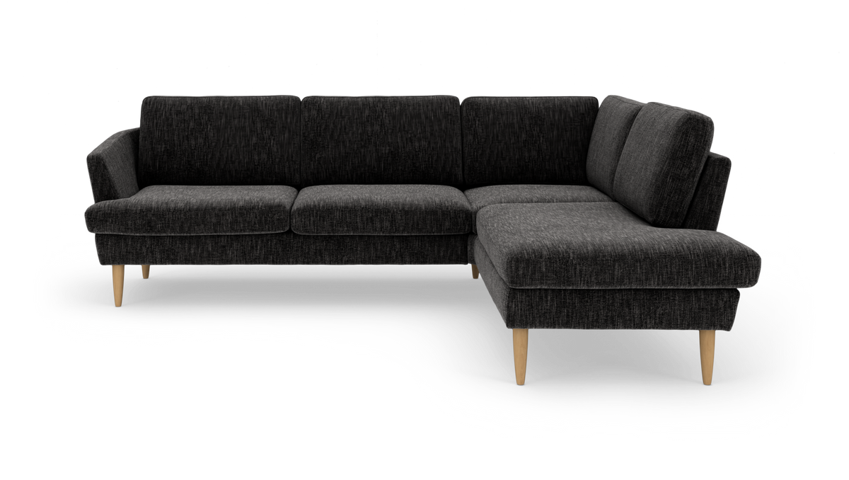 Mørkegrå L‑formet hjørnesofa med træben, fotograferet i studie og let vinklet forfra.