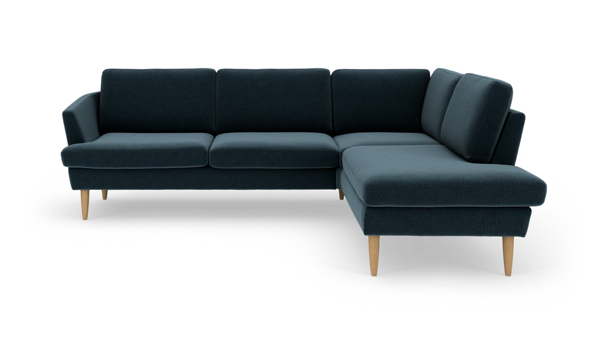 Mørk petrolblå hjørnesofa med chaiselong højre og lyse træben, frilagt på hvid baggrund.