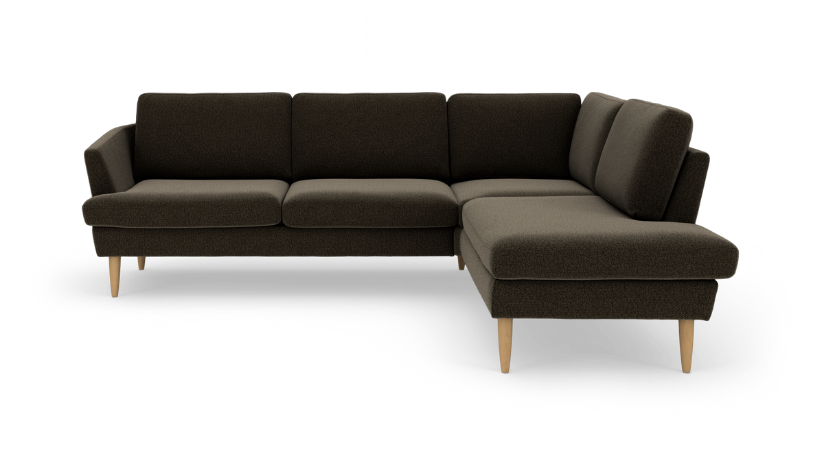 Mørkebrun L-sofa med chaiselong til højre og lyse træben, frilagt på hvid baggrund.