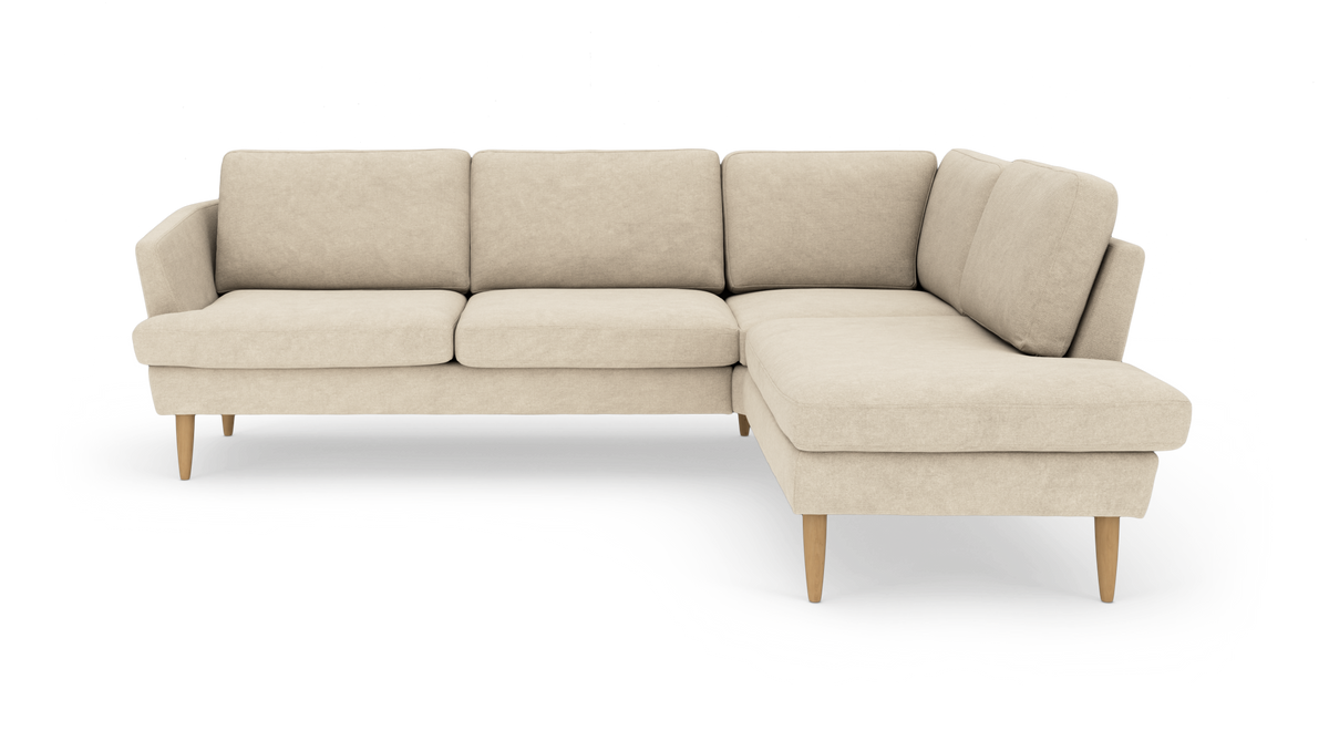 Beige L‑sofa med højre chaiselong og koniske træben, fritlagt mod hvid baggrund.