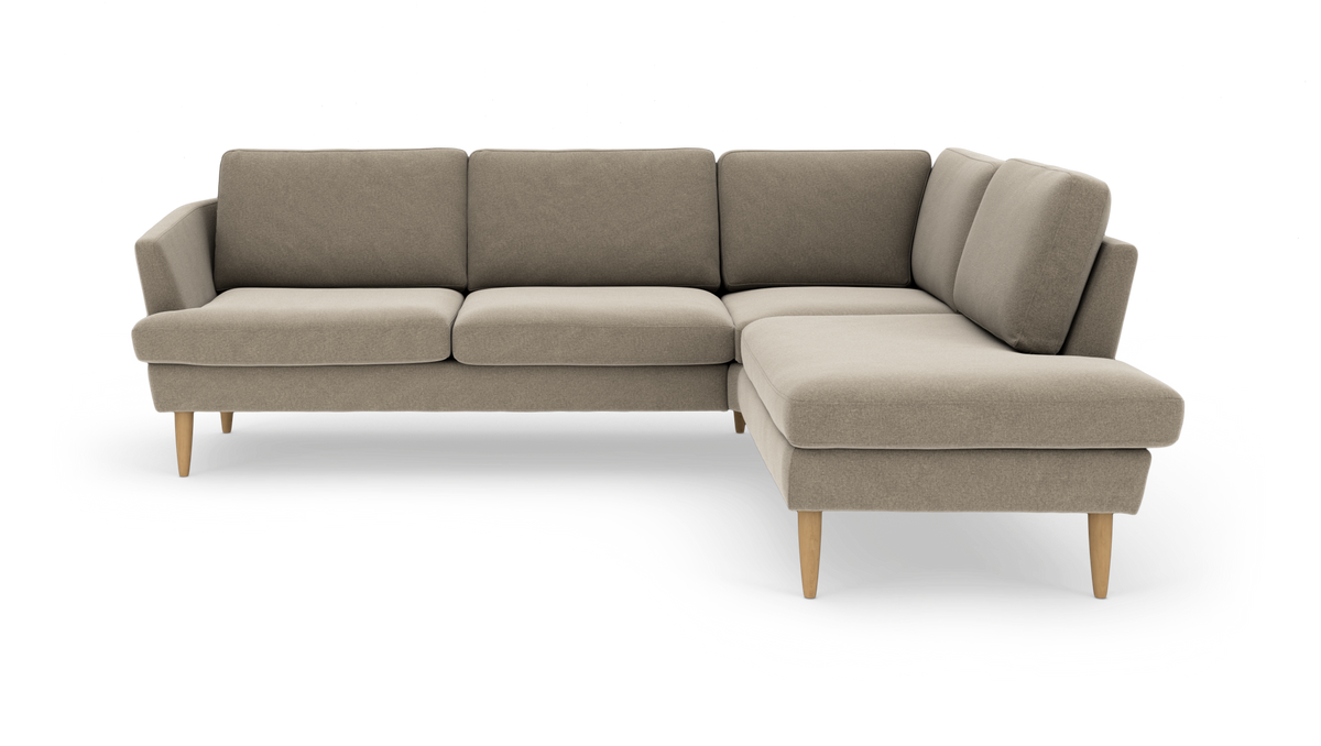 L-formet beige hjørnesofa med lyse egetræsben, frilagt på hvid baggrund.