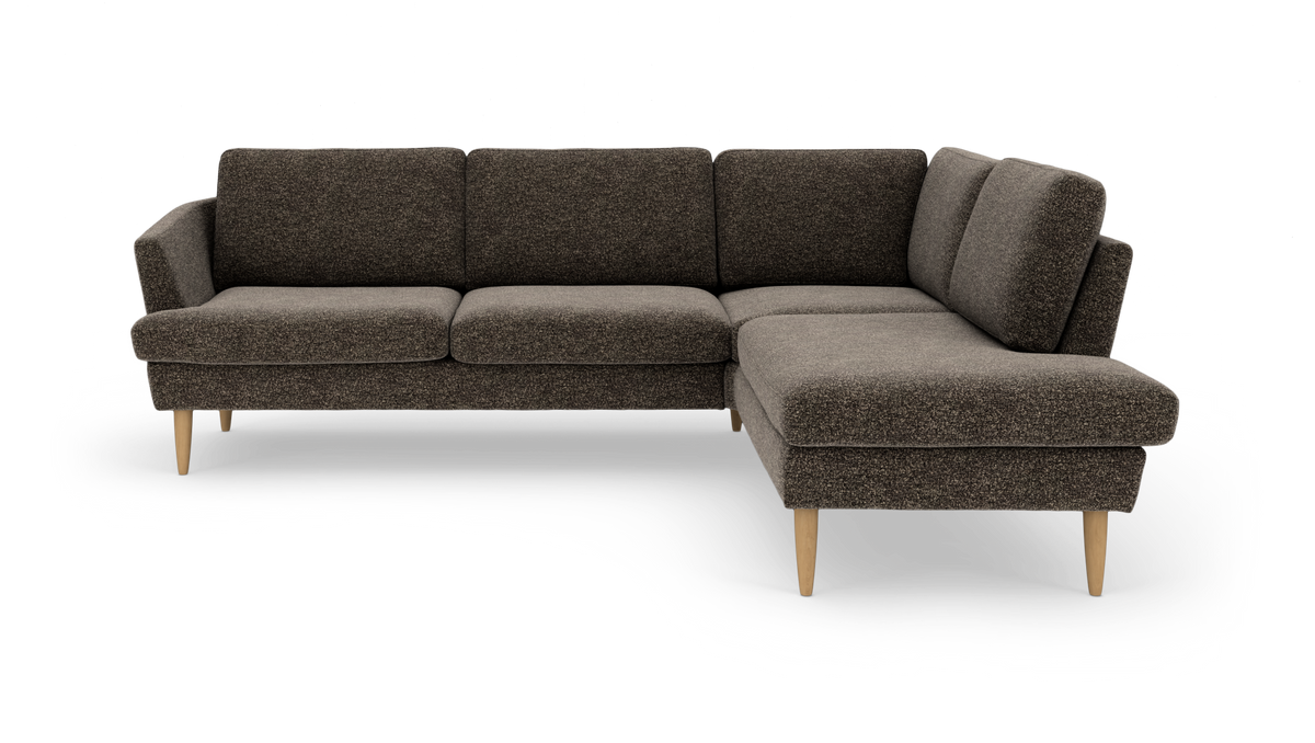 L‑sofa i mørkebrun tekstil med chaiselong til højre og lyse træben.