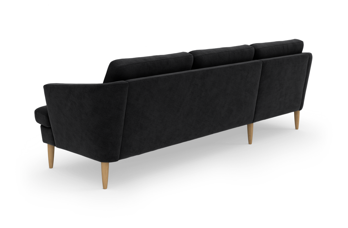 Sort 3-personers sofas i stof med slanke træben, set skråt bagfra mod hvid baggrund.