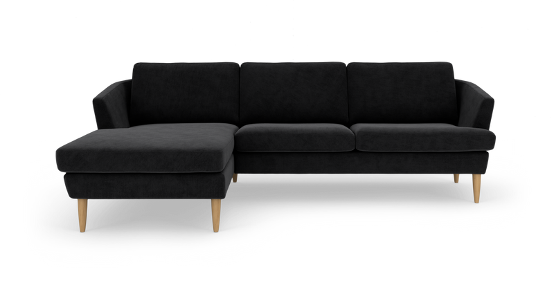 Sort hjørnesofa med venstrevendt chaiselong og lyse træben, frilagt på hvid baggrund._ps