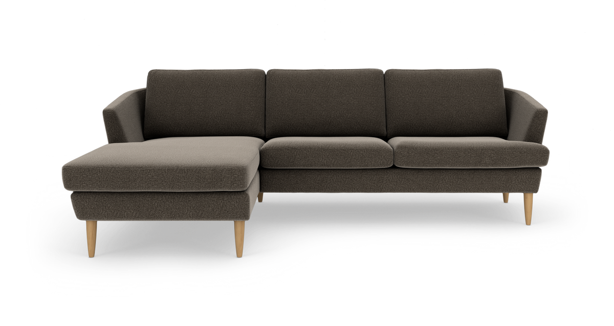 Mørkegrå hjørnesofa med venstrevendt chaiselong og træben, frilagt på hvid baggrund.