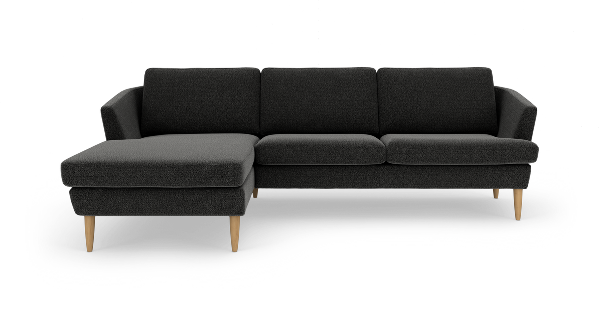 Mørkegrå hjørnesofa med venstrevendt chaiselong og lyse træben.