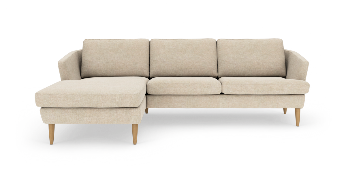 Beige hjørnesofa med venstrevendt chaiselong og træben, fotograferet lige forfra.