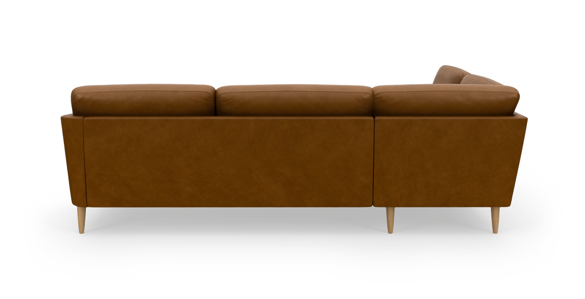 Brun lædersofa set bagfra i studie med runde træben.