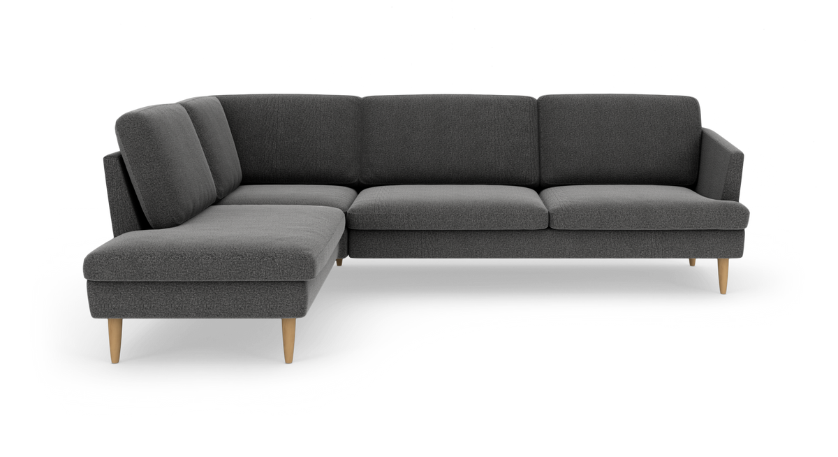 Mørkegrå hjørnesofa med venstrevendt chaiselong og lyse træben, frilagt på hvid baggrund.