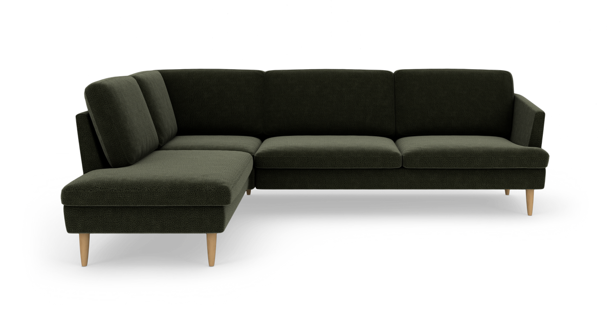 Mørkegrøn L‑sofa med venstrevendt chaiselong og koniske træben, fritlagt på hvid baggrund.