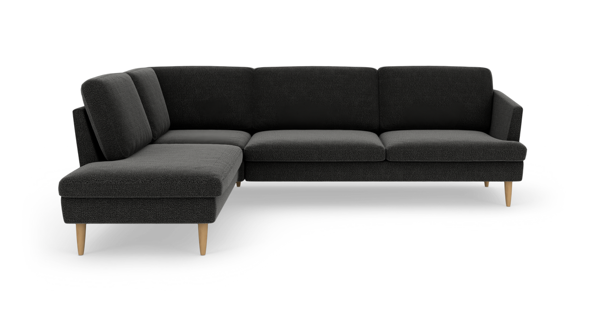 Mørkegrå hjørnesofa med venstre chaiselong og lyse, koniske træben, frilagt på hvid baggrund.