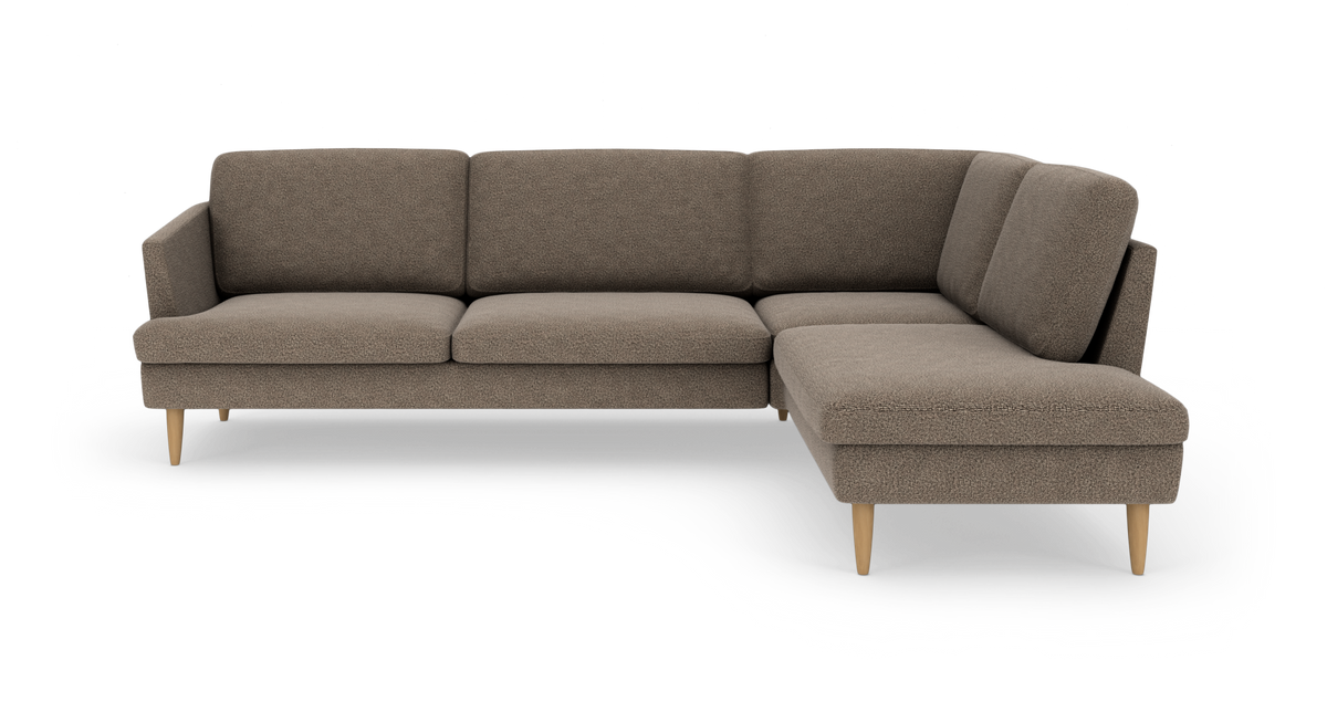 Brun L-formet hjørnesofa med chaiselong til højre, tekstil i struktureret bouclé og koniske træben, frilagt på hvid baggrund.