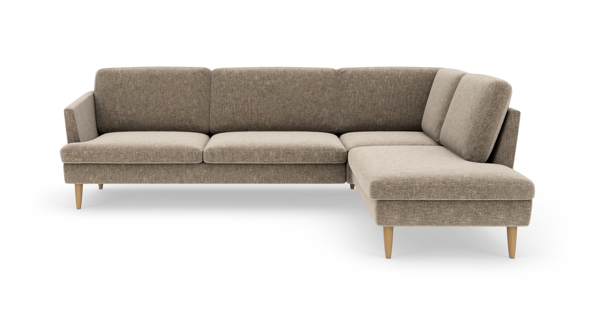 L-formet beige modulsofa med chaiselong til højre og lyse træben, frilagt på hvid baggrund.
