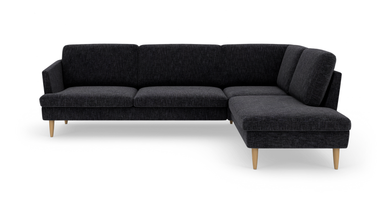 Mørkegrå L-formet sofa med chaiselong til højre og lyse træben._ps