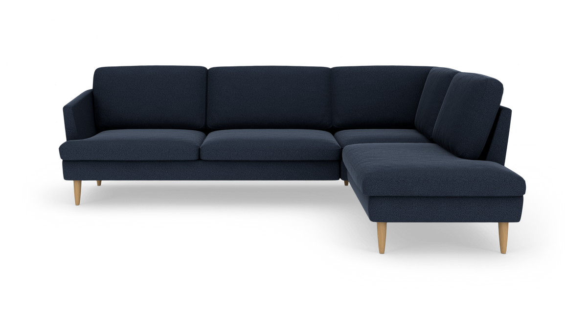 Mørkeblå hjørnesofa med højre chaiselong og lyse træben.