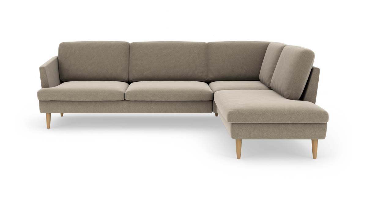 Beige L‑sofa med chaiselong til højre, træben og rene linjer.