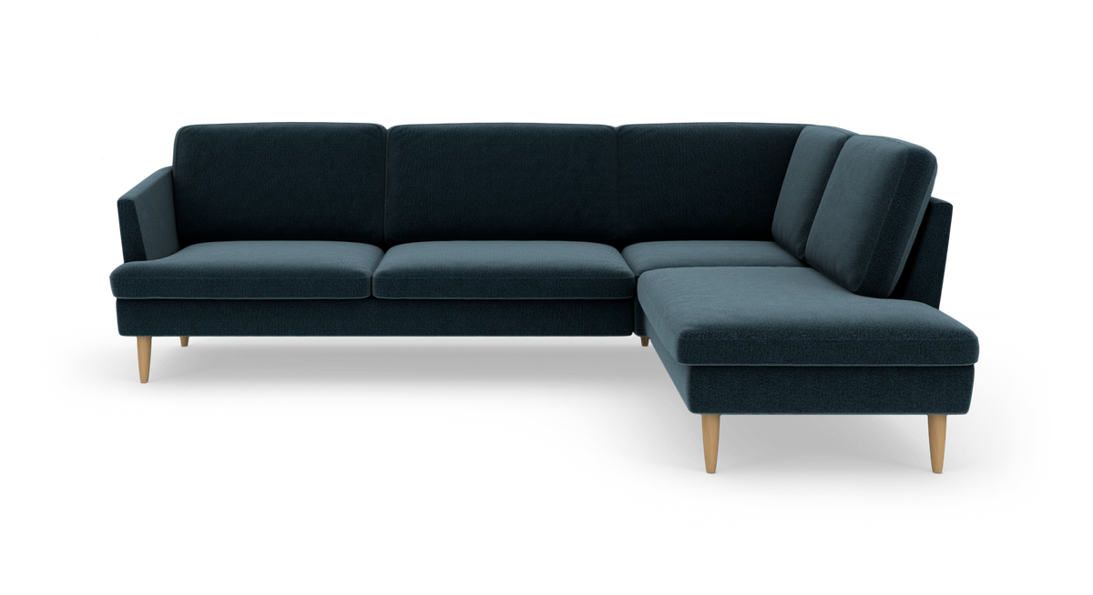 Mørkeblå hjørnesofa med chaiselong til højre og lyse træben.