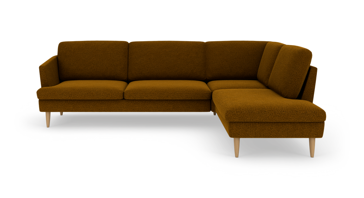 Modulær hjørnesofa i sennepsgul/brun bouclé med chaiselong til højre og koniske træben, frilagt på hvid baggrund.