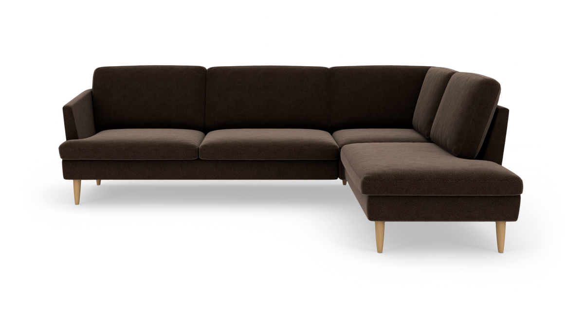 Mørkebrun L-sofa med chaiselong til højre og lyse træben, frilagt på hvid baggrund.