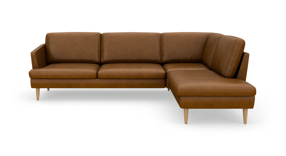 Brun L‑formet lædersofa med chaiselong til højre på lyse træben.