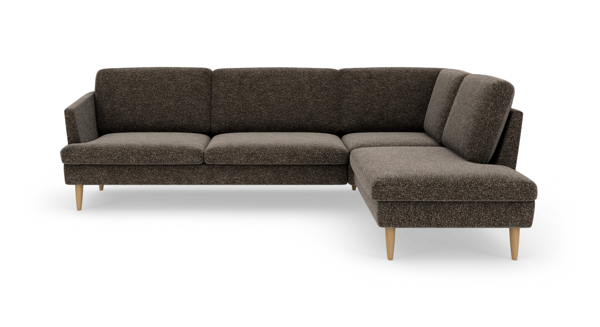 Mørkebrun hjørnesofa med chaiselong til højre og lyse træben.