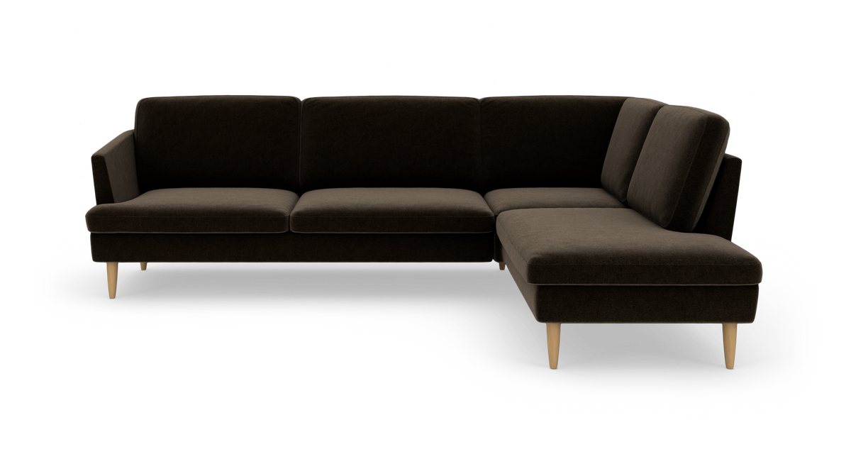 Mørkebrun L‑sofa med chaiselong til højre og lyse, koniske træben i moderne, minimalistisk stil.