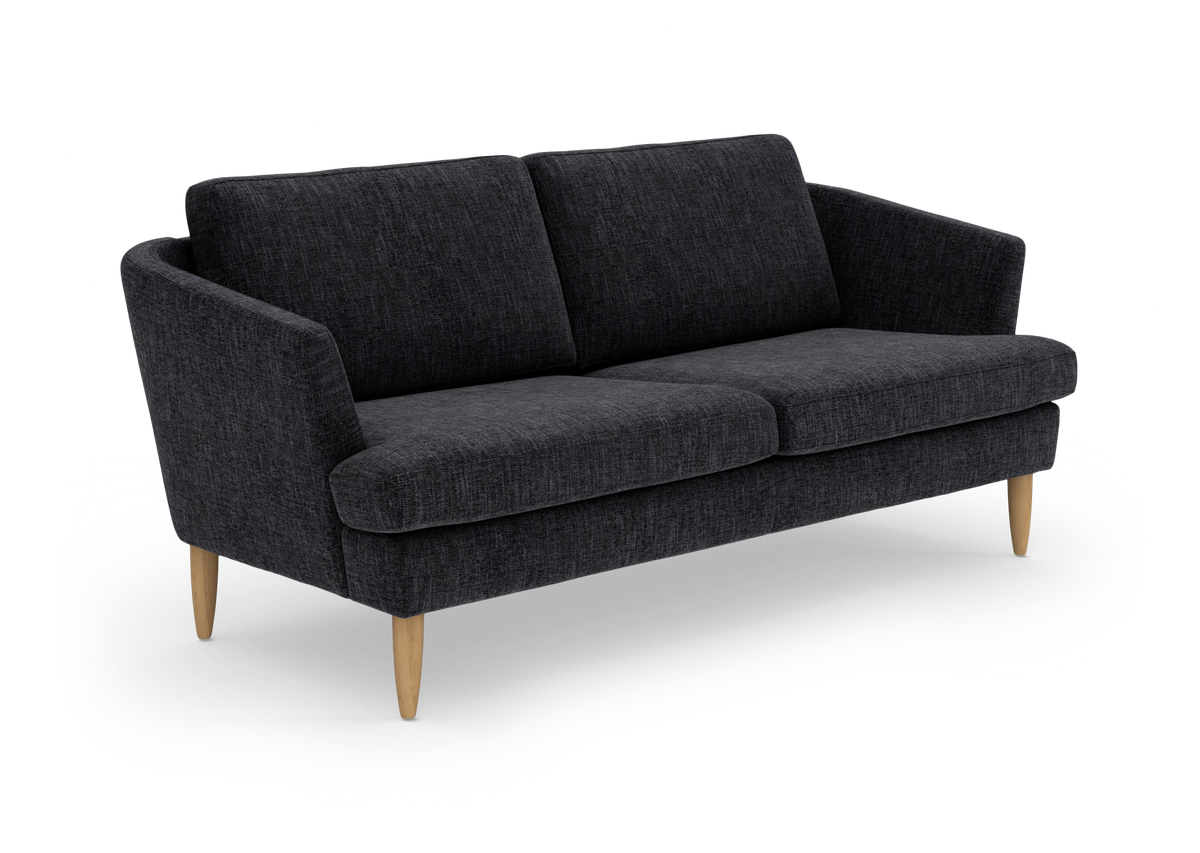 Mørkegrå stofsofa med to sæde- og ryghynder samt koniske træben, frilagt mod hvid baggrund.