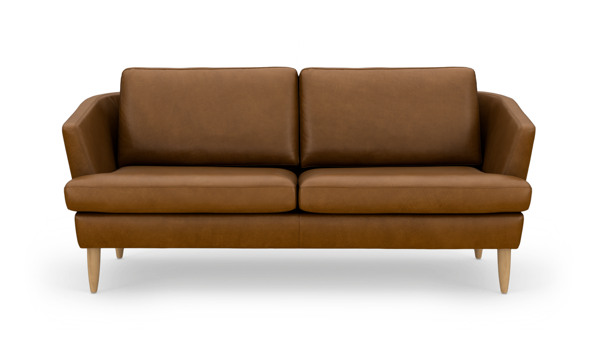 Brun lædersofa med træben, frontvisning, frilagt på hvid baggrund.